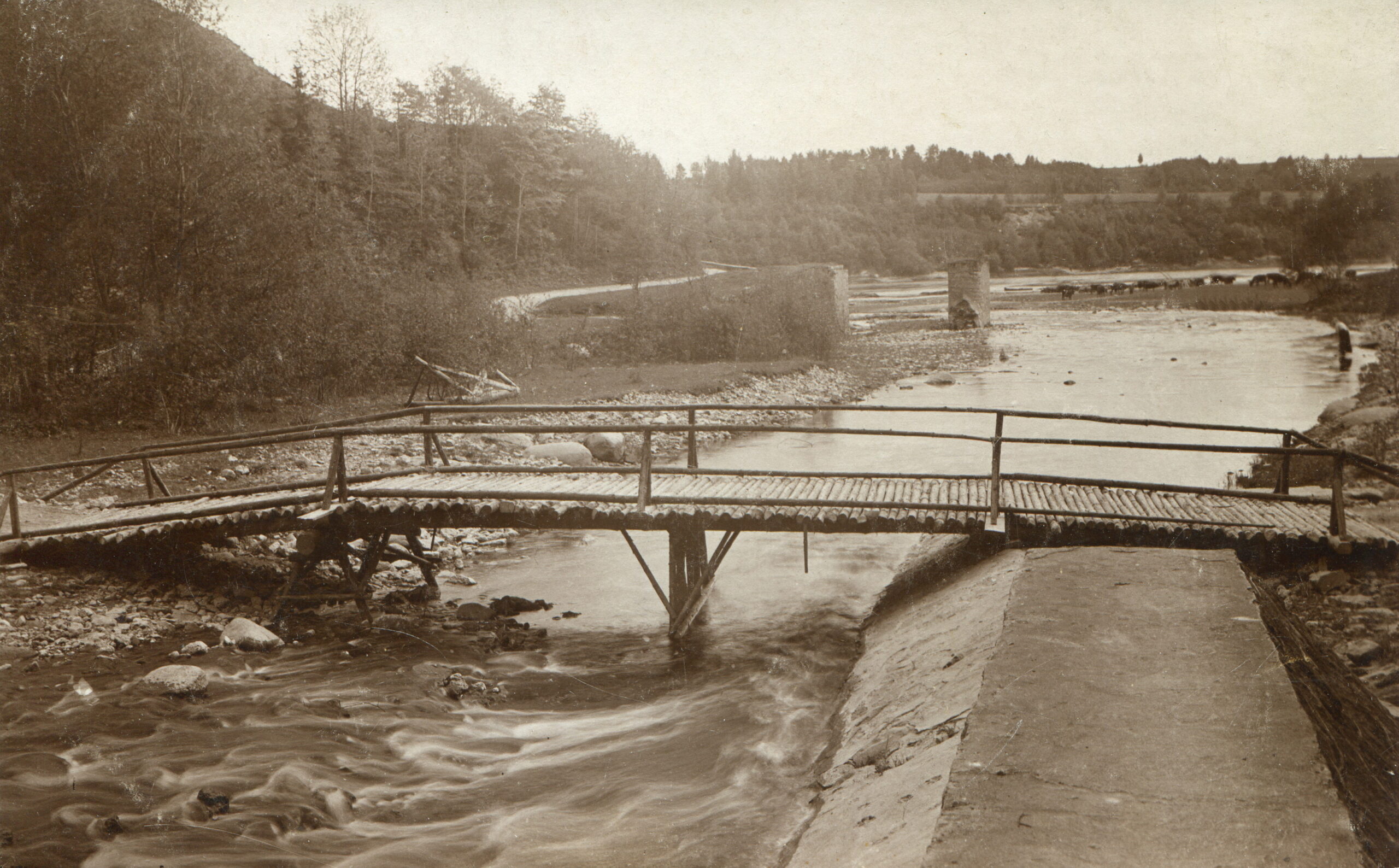 Pagaidu tilts pār Pērses atteku, kura gals balstās uz Bilstiņu krasta aizsargmūri. Tālumā redzami bijušā vecā tilta balsti. Nezināma autora 1920-os gados uzņemts foto no Daugavas muzeja krājuma.